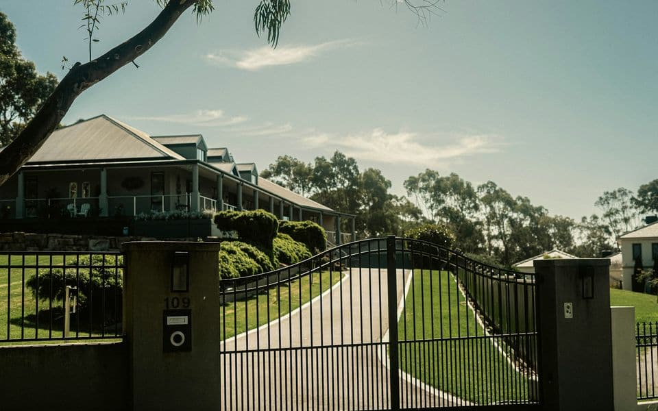 A private residential driveway gate leading to a modern villa compound